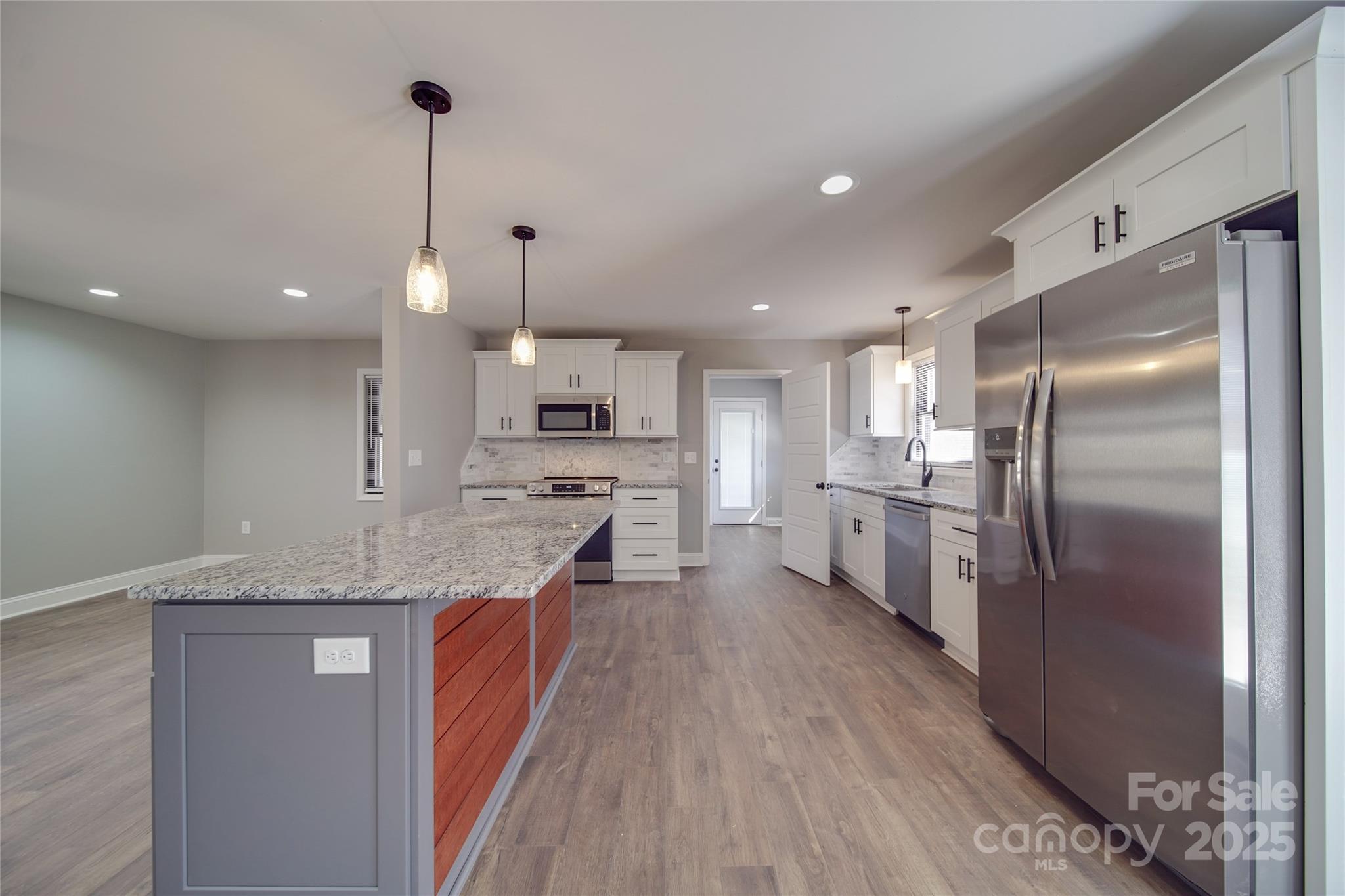 3210 Puetts Chapel Road Dallas, NC 28034 - Photo 3 of 11 a kitchen with stainless steel appliances granite countertop a refrigerator a oven a sink and white cabinets with wooden floor