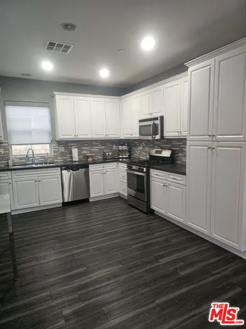 a kitchen with granite countertop a sink and cabinets