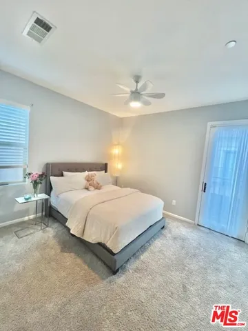a spacious bedroom with a bed and a chandelier