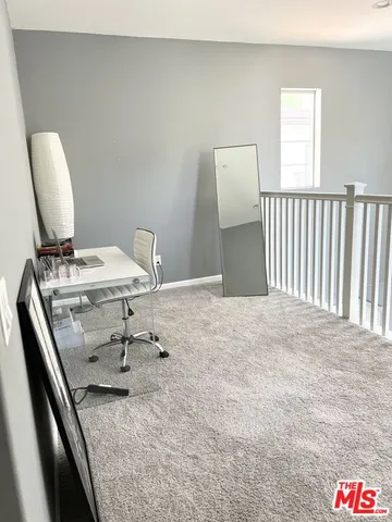 a view of a hallway to a livingroom with furniture