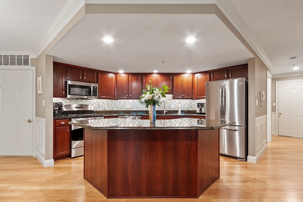 4 Sterling Hill Lane, Unit 424 Exeter, NH 03833 - Photo 3 of 24 a kitchen with stainless steel appliances granite countertop wooden cabinets a refrigerator and a sink