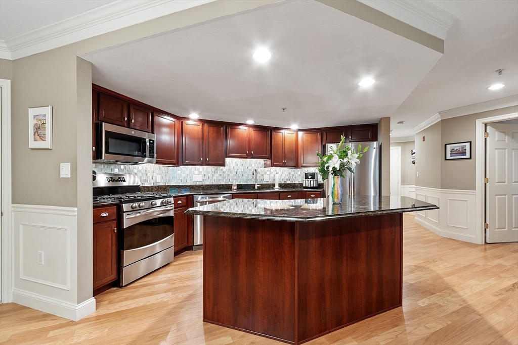 4 Sterling Hill Lane, Unit 424 Exeter, NH 03833 - Photo 4 of 24 a kitchen with stainless steel appliances granite countertop a stove and a sink