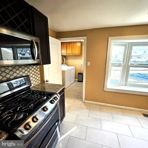 a kitchen with a stove a window and a counter top space