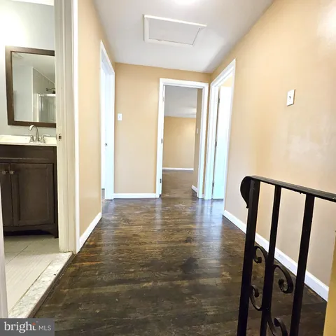 a view of a hallway with wooden floor and cabinet