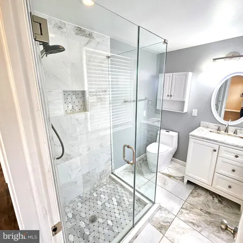 a bathroom with a granite countertop sink a mirror and a shower