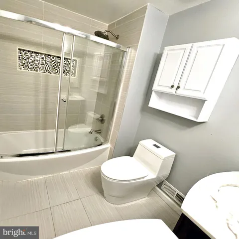 a white toilet sitting next to a bathroom sink and tub