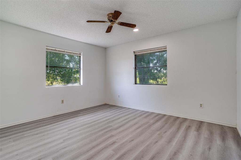 7397 Fm 1377 Blue Ridge, TX 75424 - Photo 20 of 27 an empty room with wooden floor ceiling fan and windows