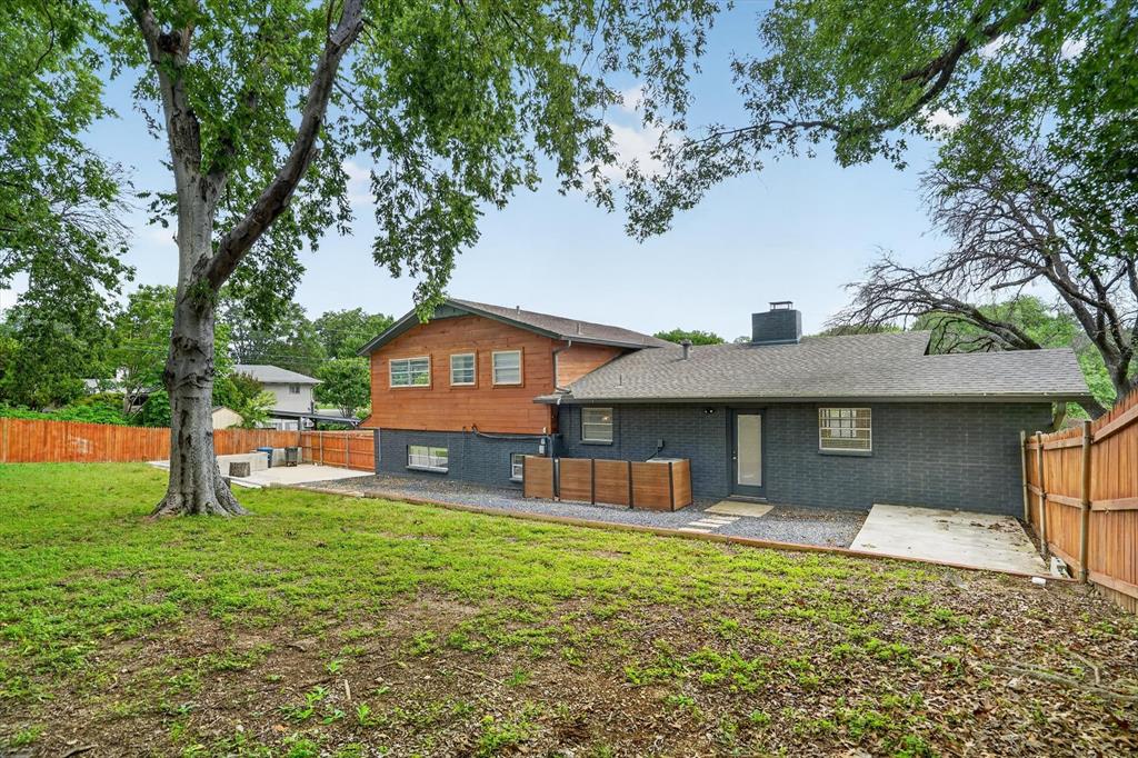 6609 Genoa Road Fort Worth, TX 76116 - Photo 38 of 40 Spacious backyard featuring a large mature tree, a privacy fence, and a combination of brick and wood siding on the exterior