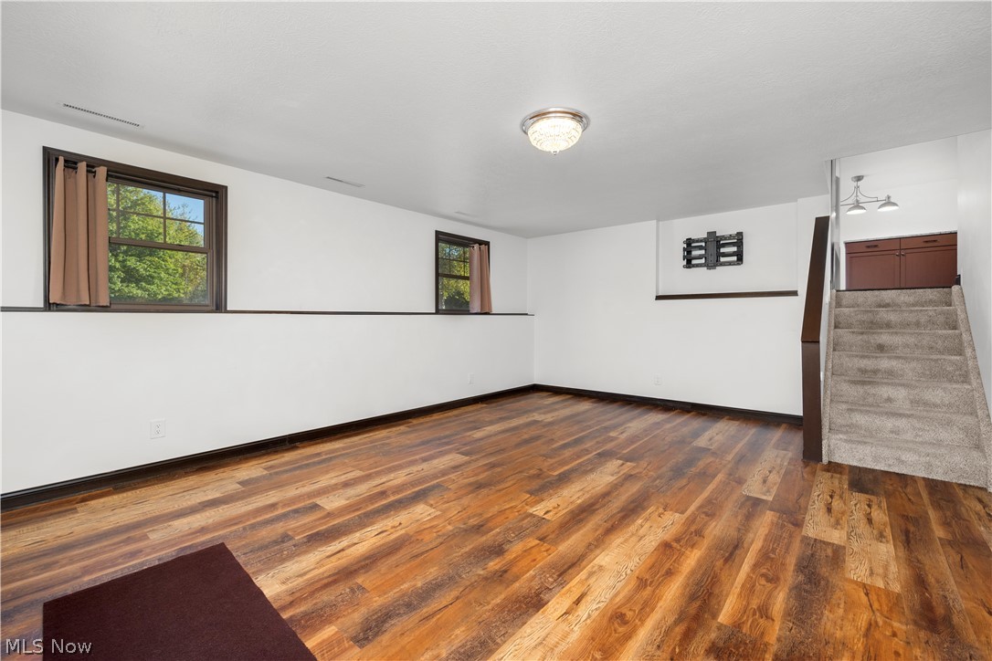 6760 Mason Road Berlin Heights, OH 44814 - Photo 29 of 49 Empty room with dark wood-style flooring and stairs
