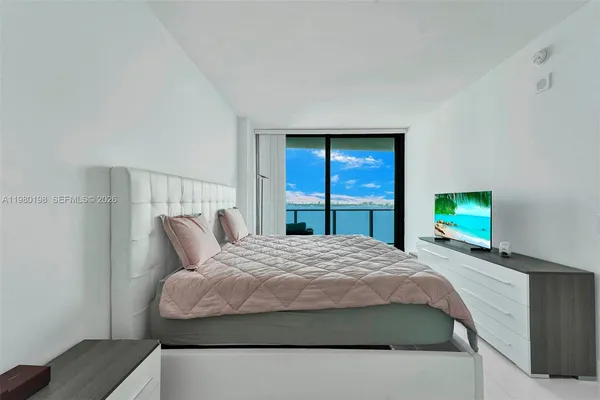 a bedroom with a bed and a mirror