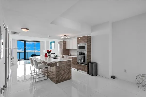 a living room with stainless steel appliances kitchen island furniture and a view of kitchen