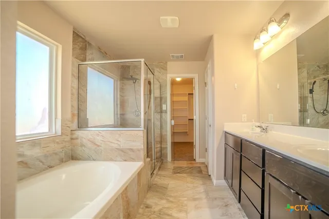 a bathroom with a tub sink and mirror