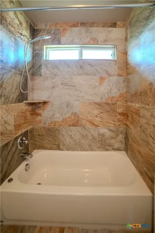 a bathroom with a bathtub and shower