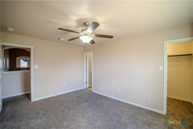 a view of a big room with closet and a chandelier fan