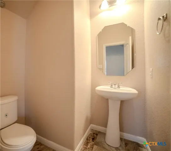 a bathroom with a sink mirror and toilet