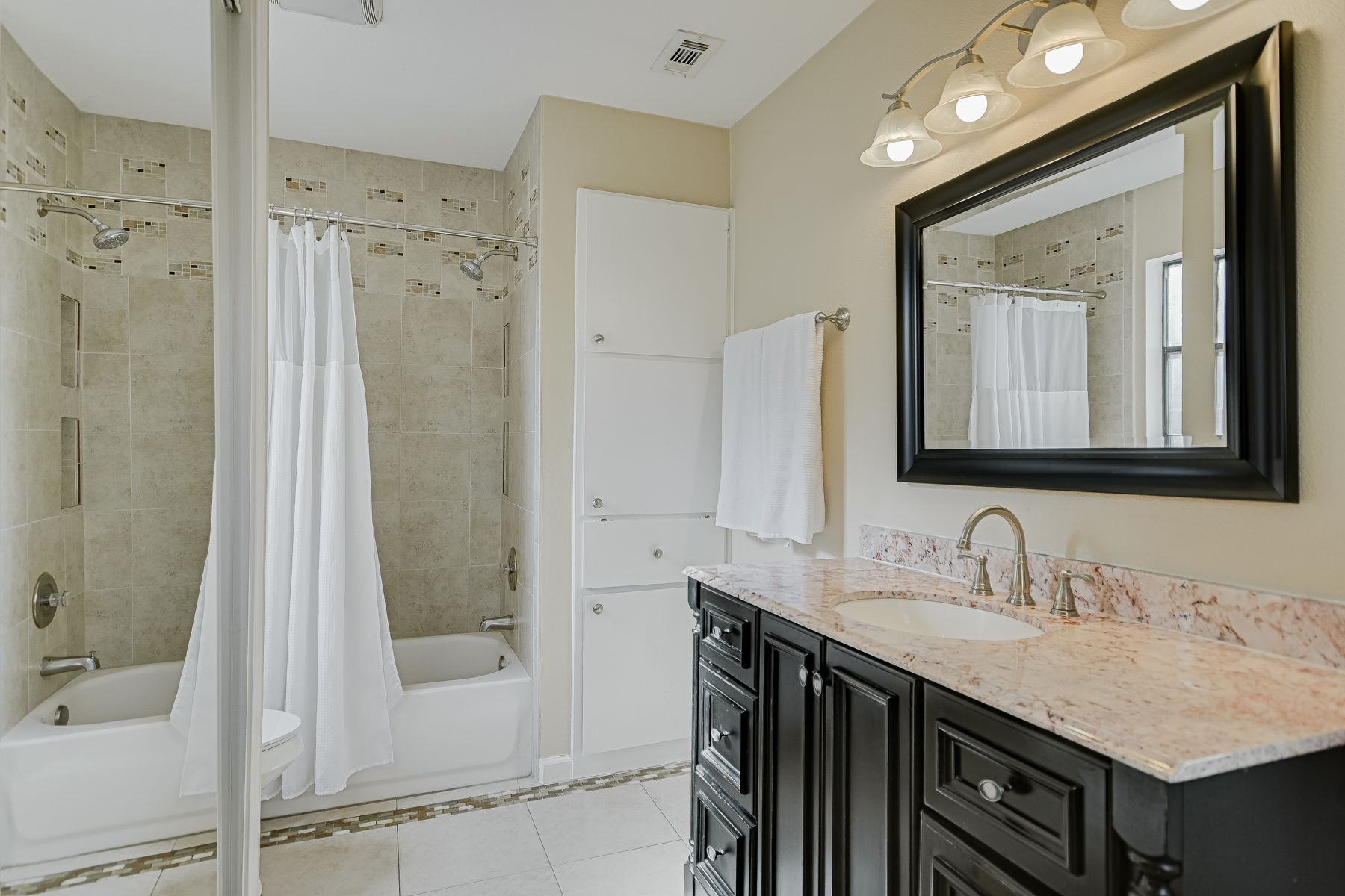 2605 Garrettson Drive, Unit A Austin, TX 78748 - Photo 11 of 21 a bathroom with a granite countertop sink mirror and a shower