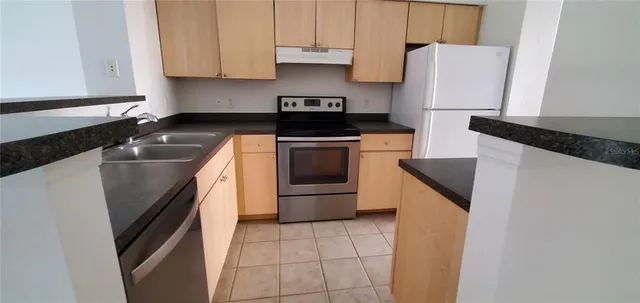 a kitchen with stainless steel appliances a sink stove and refrigerator