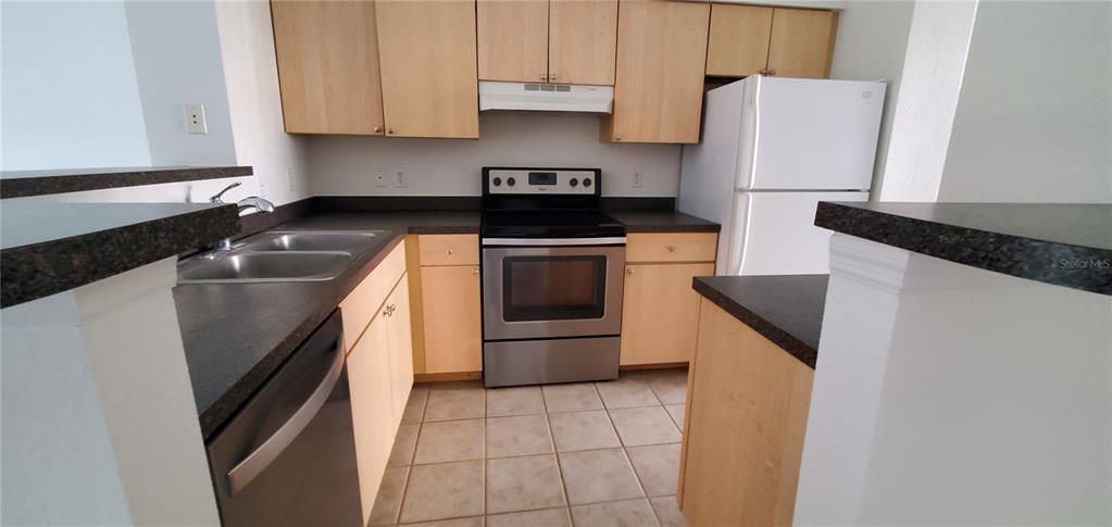 3584 Kings Road, Unit 101 Palm Harbor, FL 34685 - Photo 8 of 17 a kitchen with a sink a stove and cabinets