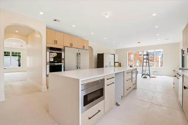 a large white kitchen with lots of counter space and glass door