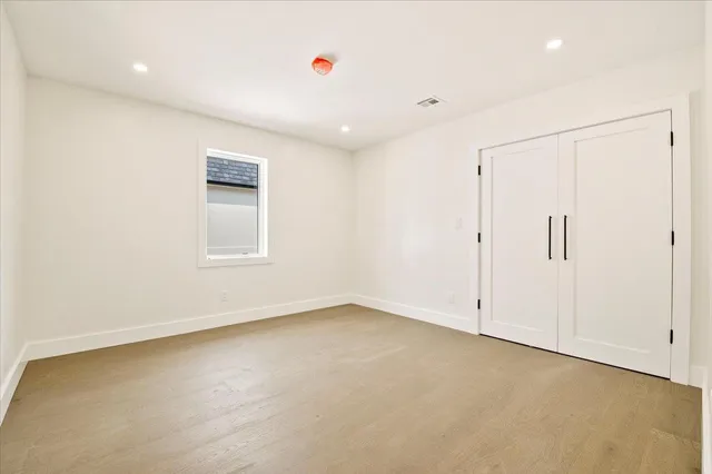 an empty room with closet and windows