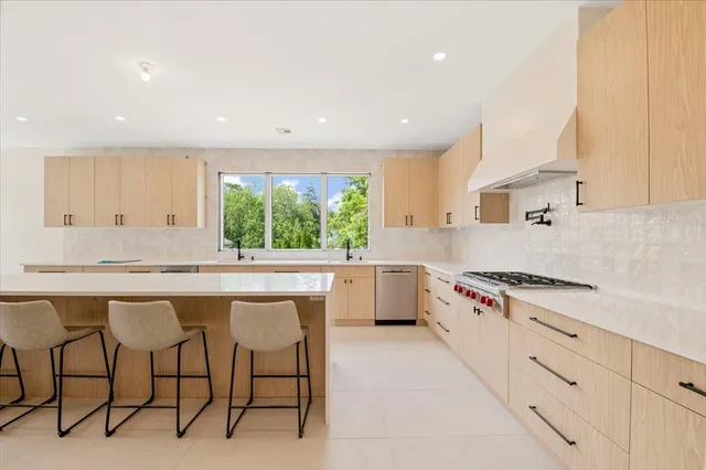 a kitchen with a table chairs sink and cabinets