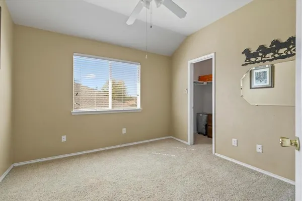 a view of empty room with windows and chandelier fan
