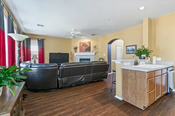 a kitchen with kitchen island a dining table chairs stainless steel appliances and wooden floor
