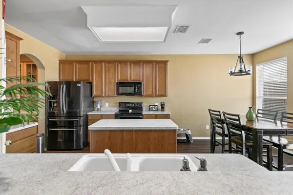 a kitchen with stainless steel appliances granite countertop a refrigerator a stove top oven a sink and dishwasher