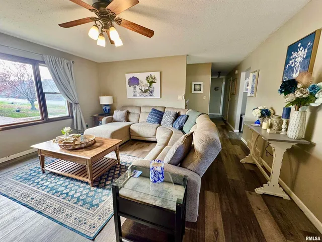 a living room with furniture a flat screen tv and a large window