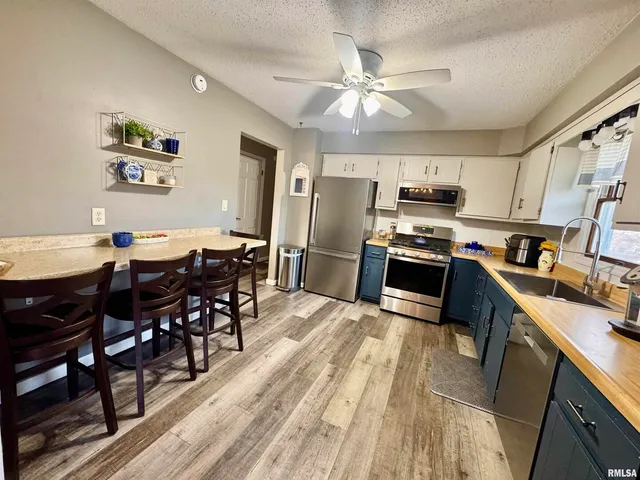 a view of a dining room with furniture a kitchen and chandelier