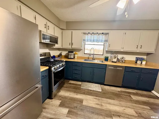 a kitchen with stainless steel appliances granite countertop a stove a sink dishwasher and a refrigerator