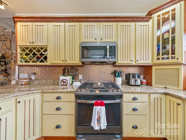a kitchen with stainless steel appliances granite countertop a stove a sink and a microwave