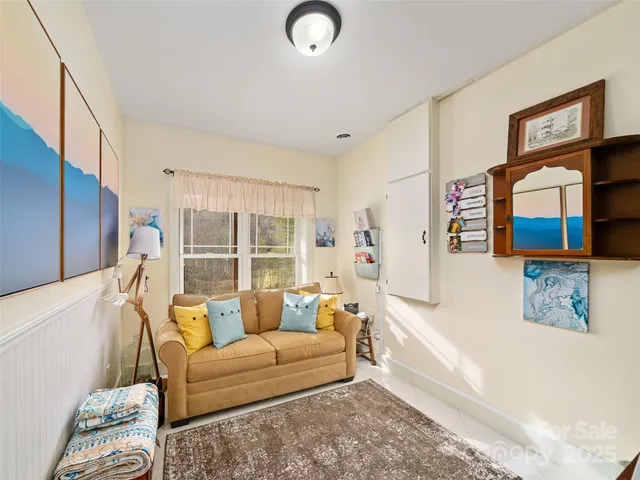 a living room with furniture and a floor to ceiling window