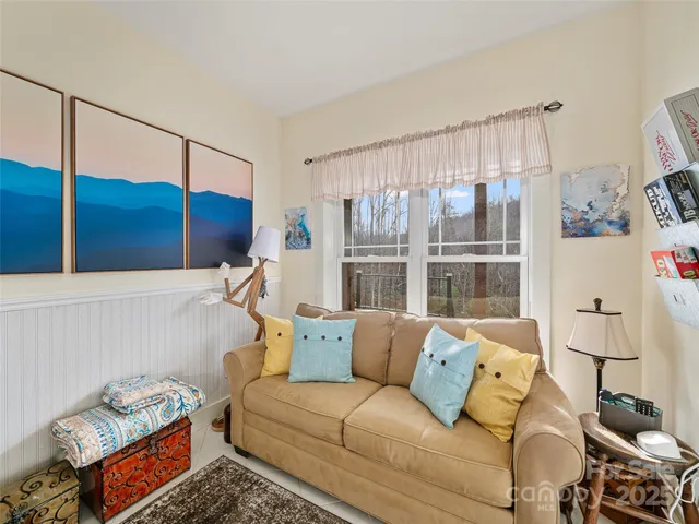 a living room with furniture and a painting on the wall