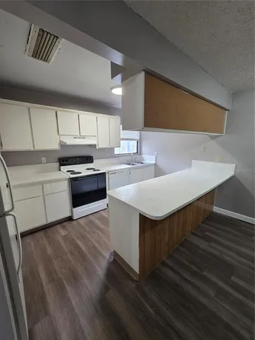 a kitchen with a sink cabinets and wooden floor