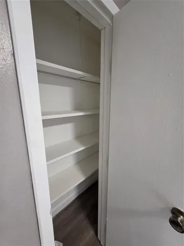 a view of walk in closet with empty racks