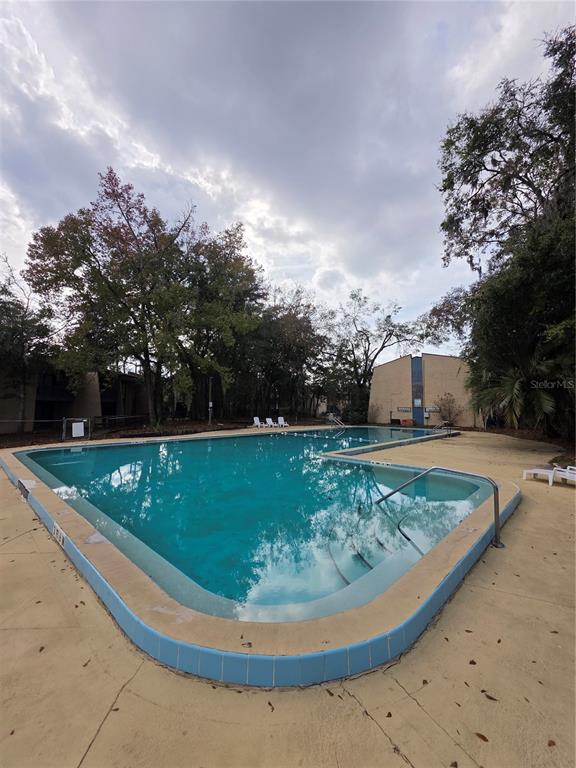 2811 Southwest Archer Road, Unit R142 Gainesville, FL 32608 - Photo 29 of 30 a view of a swimming pool with a yard and plants