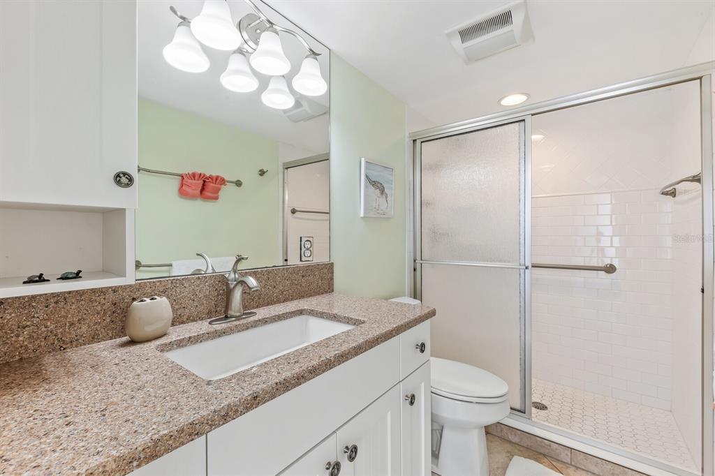 5000 Gasparilla Road, Unit BC306 Boca Grande, FL 33921 - Photo 11 of 35 a bathroom with a granite countertop sink mirror vanity and toilet