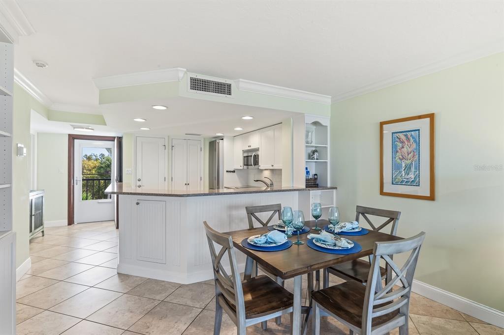 5000 Gasparilla Road, Unit BC306 Boca Grande, FL 33921 - Photo 8 of 35 a view of a dining room and livingroom with furniture wooden floor and a rug