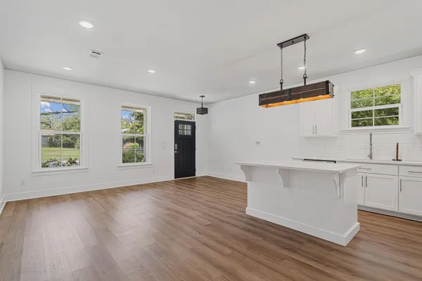 a view of a kitchen with a sink wooden floor and windows