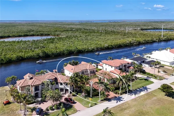 an aerial view of a house with swimming pool large trees and buildings