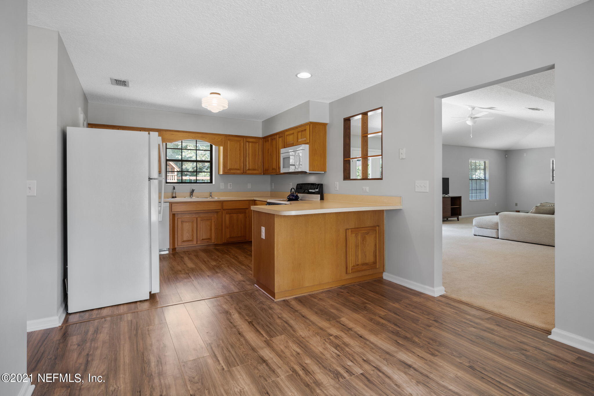 736 Halsema Road North Jacksonville, FL 32220 - Photo 11 of 29 a kitchen with a sink a refrigerator and wooden floor