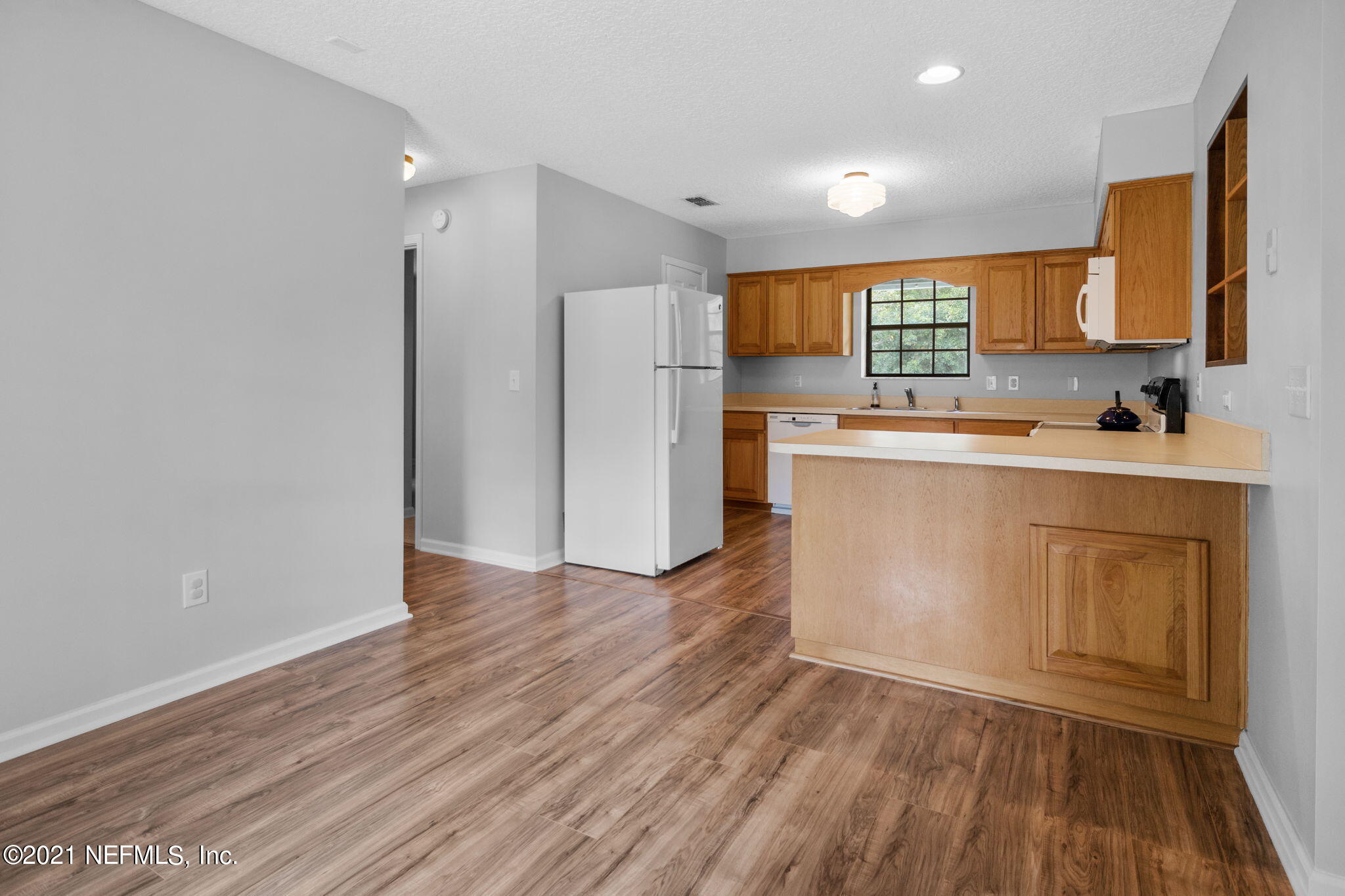 736 Halsema Road North Jacksonville, FL 32220 - Photo 10 of 29 a kitchen with a sink a refrigerator a stove and wooden floor