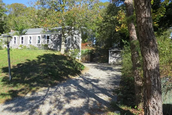 an aerial view of a house with yard and trees all around