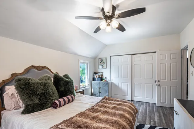 a bedroom with a bed large window and a chandelier