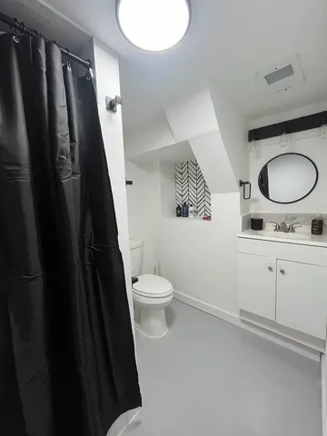 a bathroom with a granite countertop sink toilet and shower
