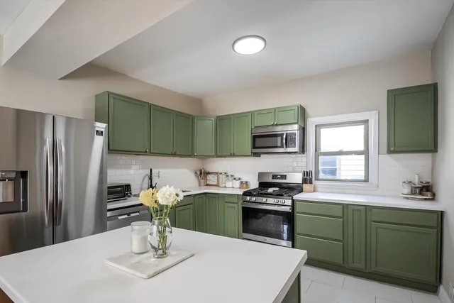 a kitchen with a sink a stove a refrigerator and chairs