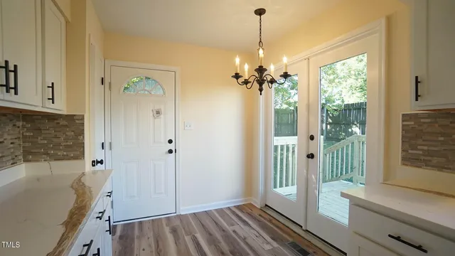 a view of a livingroom with a tub wooden floor and windows