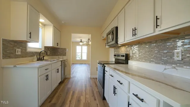 a kitchen with granite countertop white cabinets and white appliances