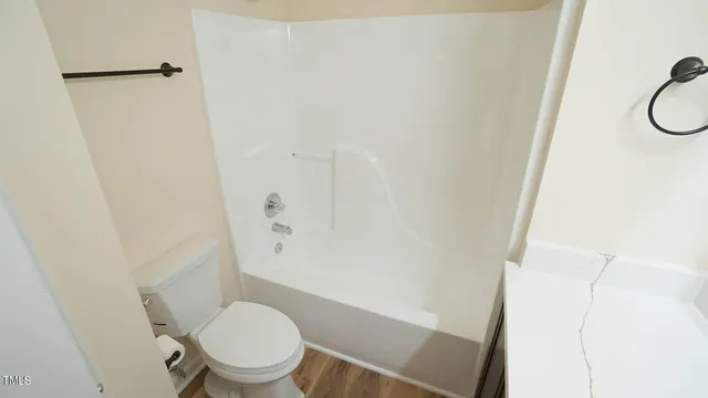 a white toilet sitting next to a shower